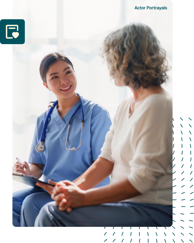 A doctor wearing a lab coat smiling warmly at a patient seated in front of them, conveying empathy and reassurance during a medical consultation.